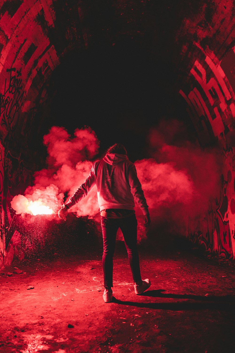 man in black hoodie standing on red light