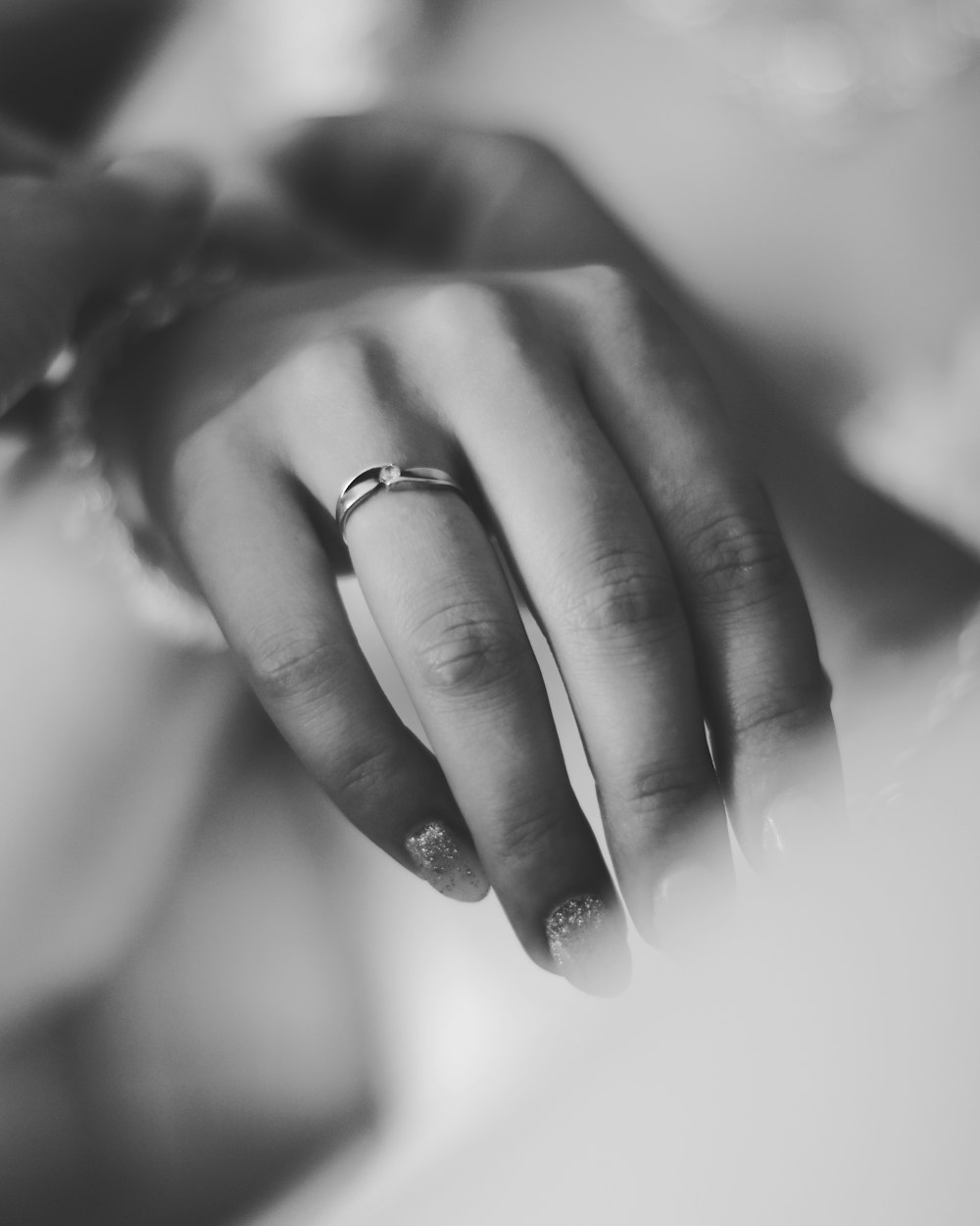 grayscale photo of person wearing ring