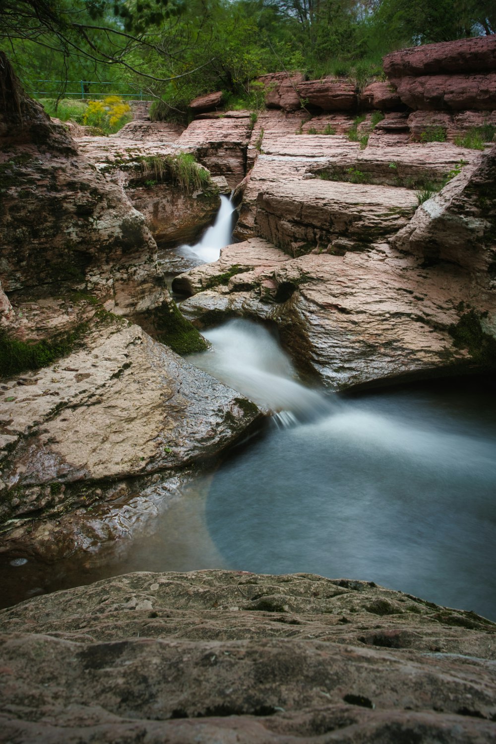 river in between brown rocks