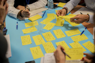 A creative team brainstorming session with colorful sticky notes and laptops open.