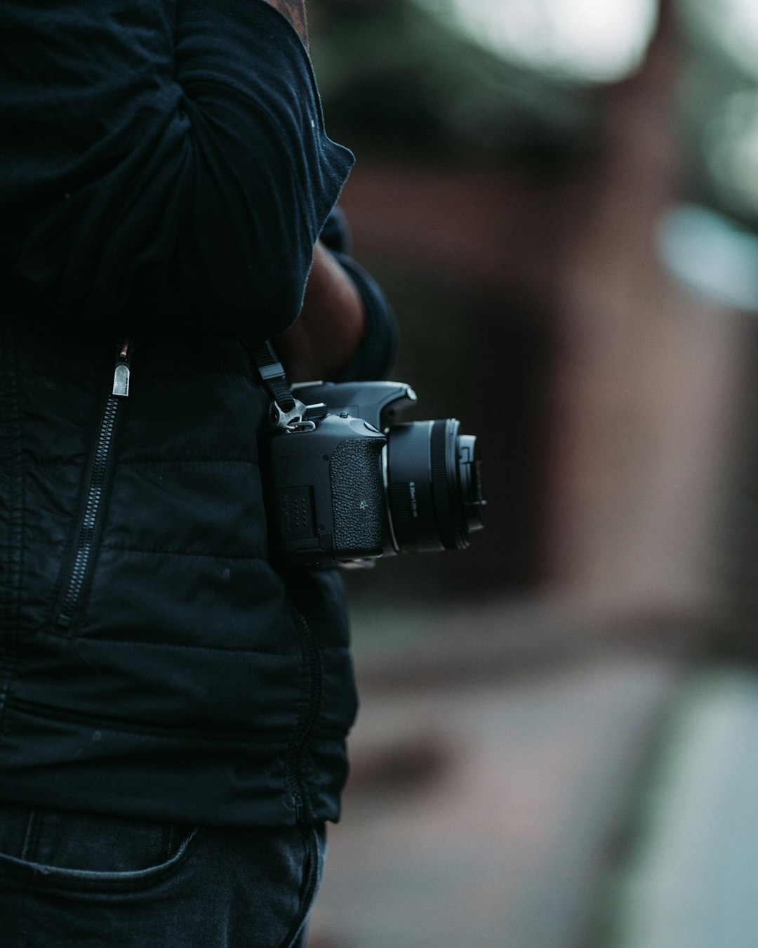 person in black leather jacket holding black dslr camera