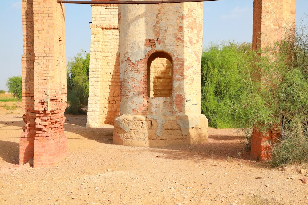 brown concrete arch near green trees during daytime