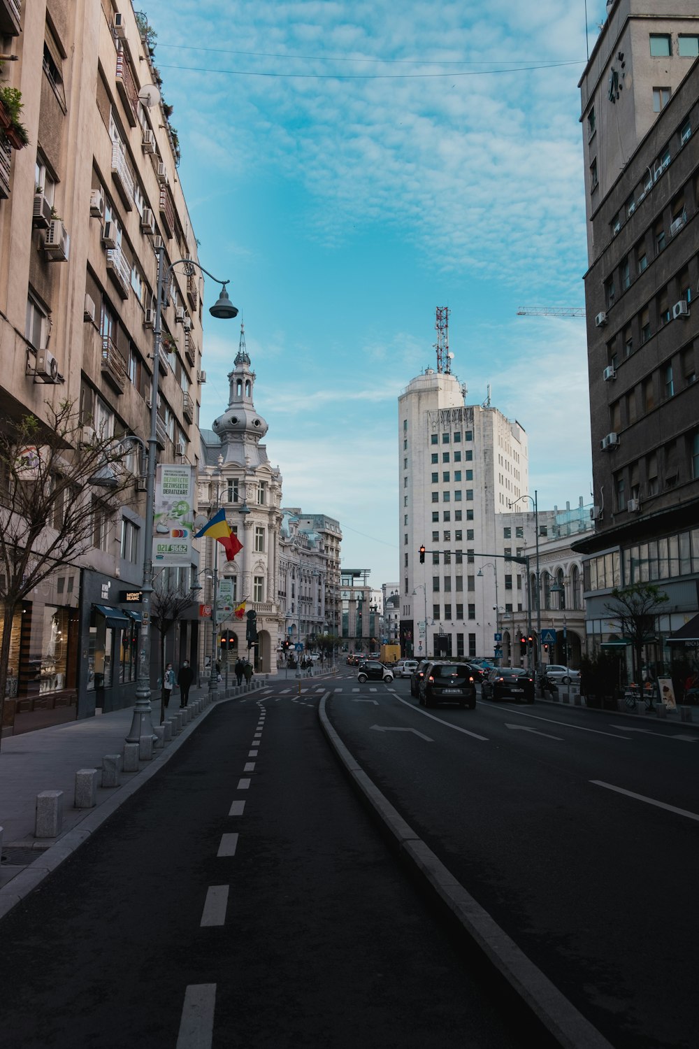 cars on road between high rise buildings during daytime