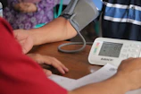 Close-up of hands gently checking a patient's blood pressure with modern equipment.