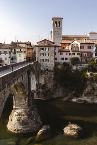 A serene European village with historic stone houses and a peaceful river flowing through.