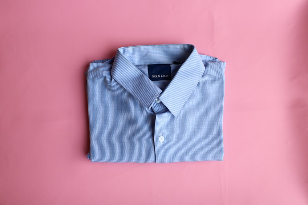 blue polo shirt on pink textile
