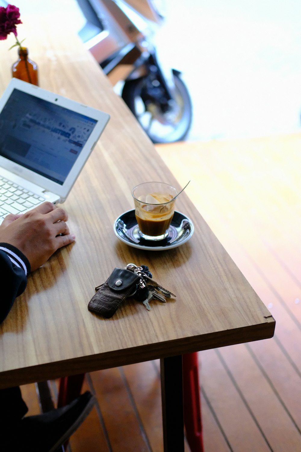 person using macbook air on brown wooden table