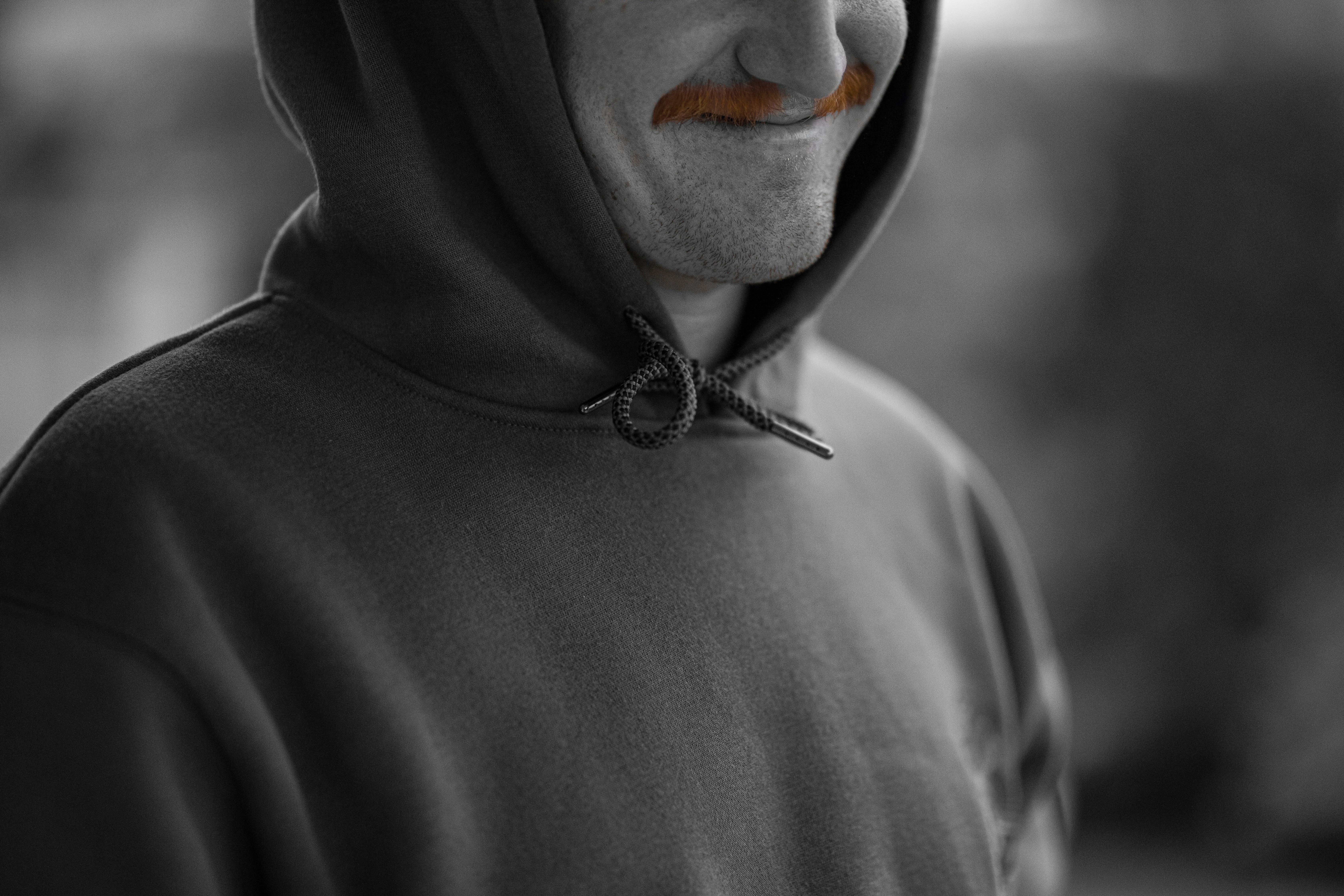 personne en sweat à capuche noir avec coeur blanc et rouge en forme de visage