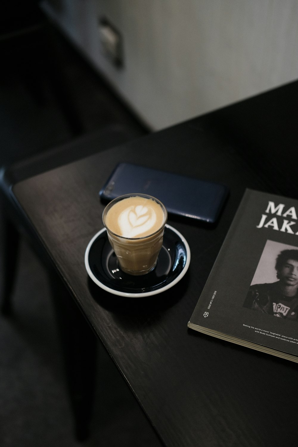 a cup of coffee and a book on a table