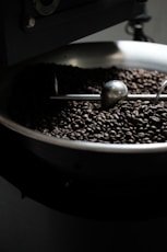 a bowl of coffee beans with a spoon in it