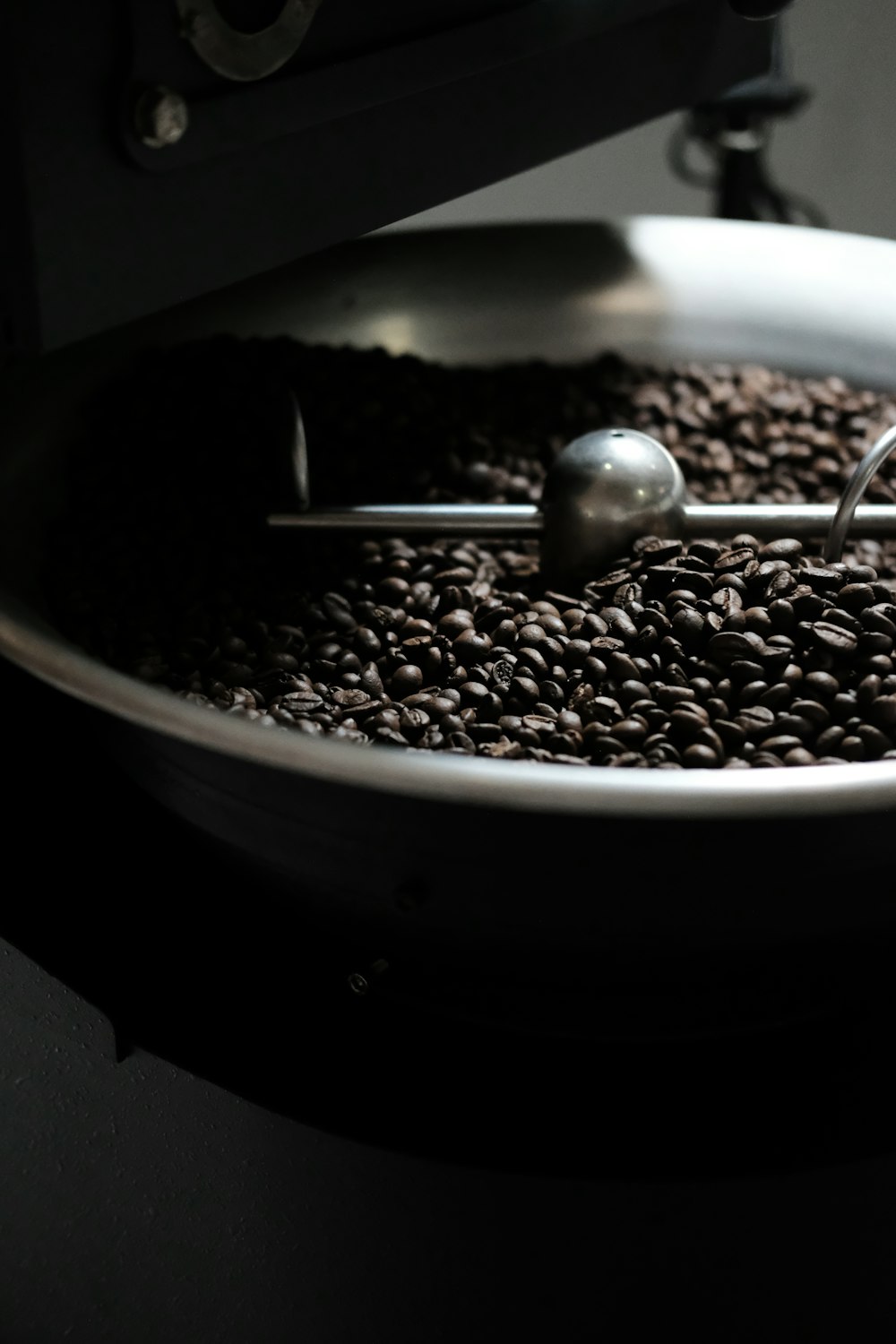 a bowl of coffee beans with a spoon in it