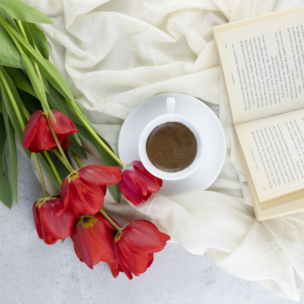 red and white tulips beside white ceramic mug with coffee