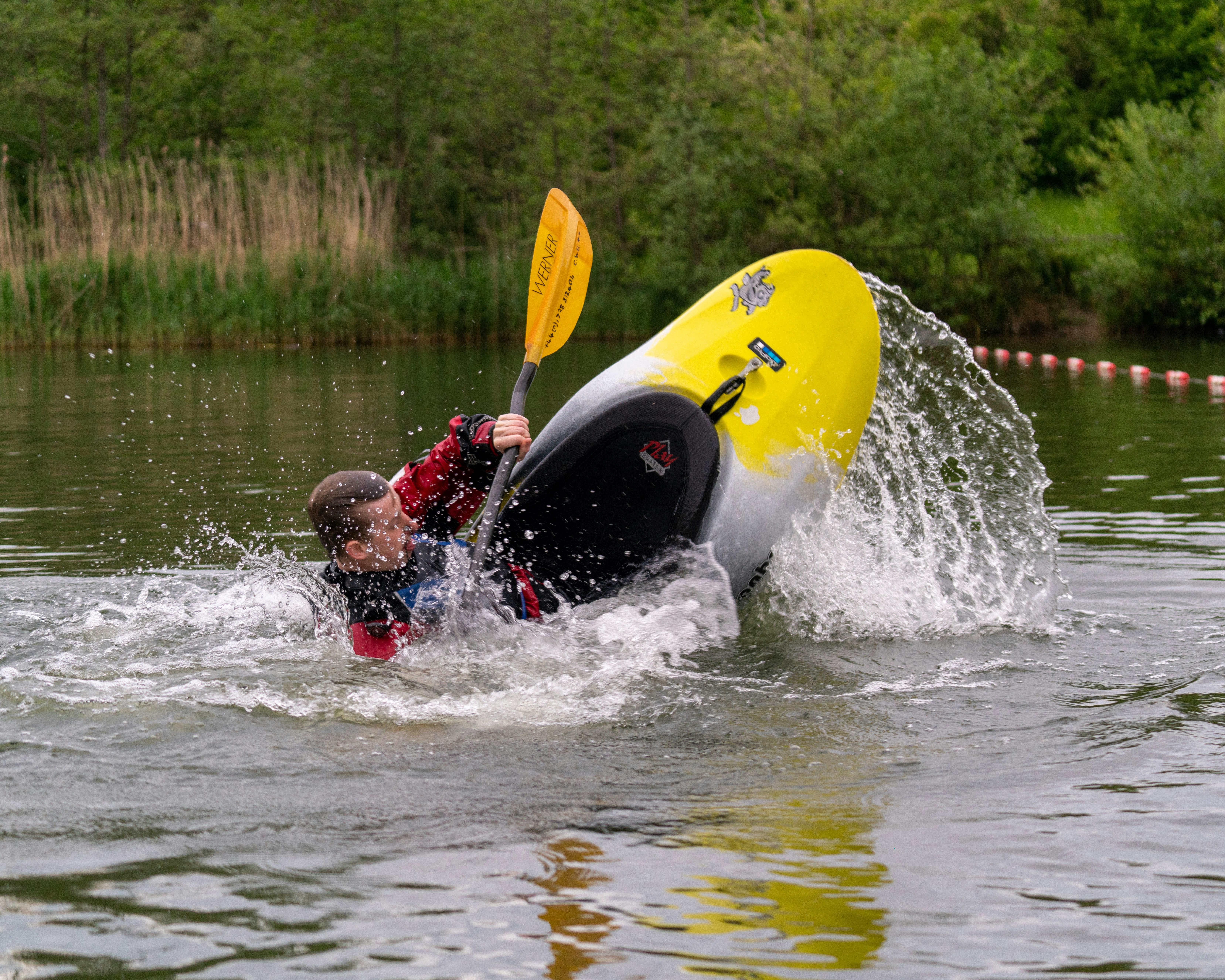 man in red shirt riding yellow surfboard on water during daytime