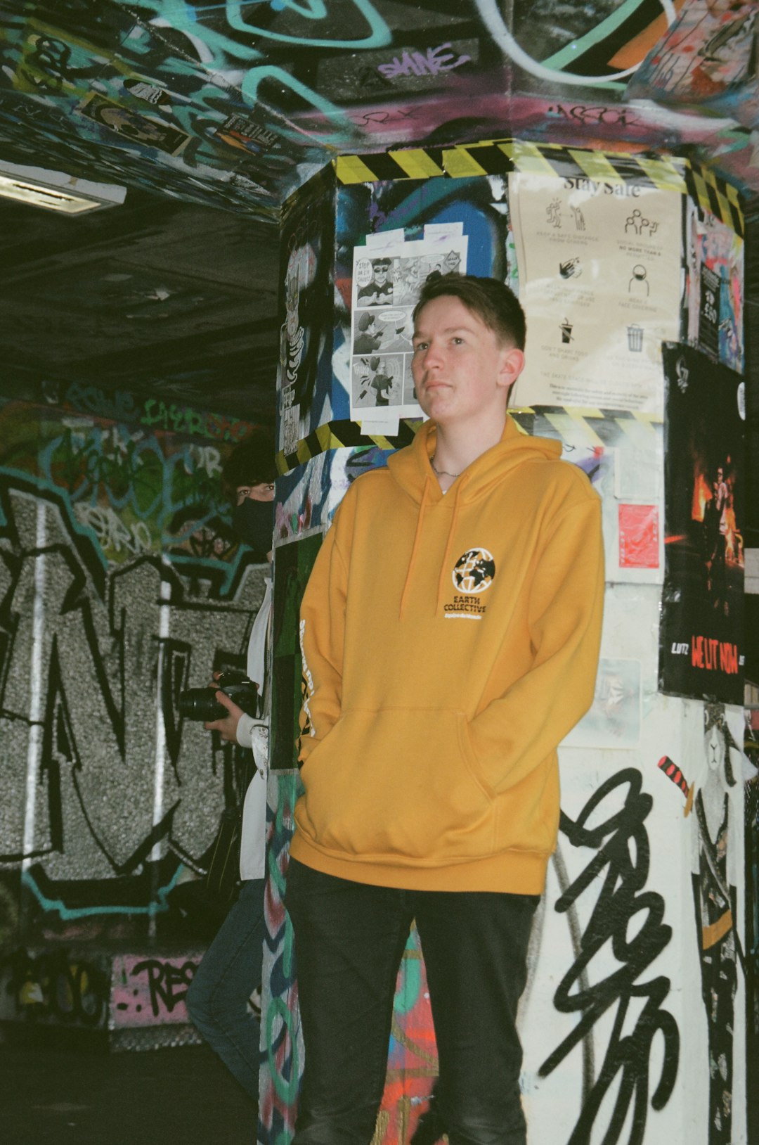 man in orange polo shirt standing near wall