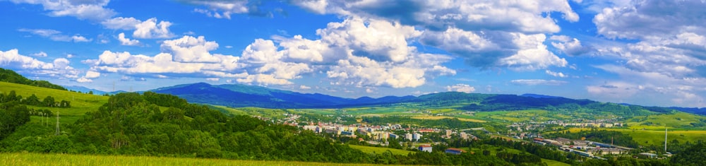 green grass field under blue sky and white clouds during daytime