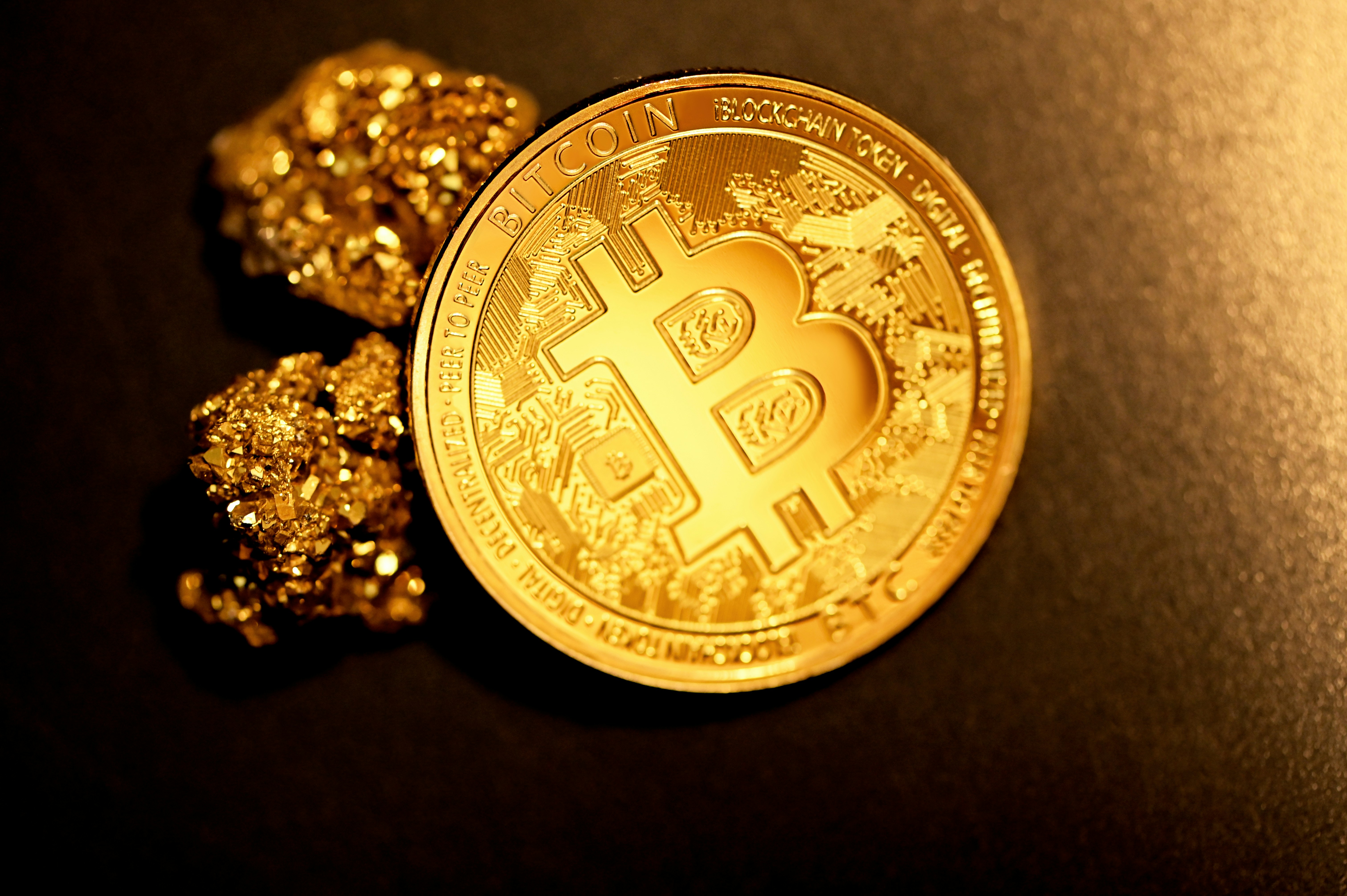 A Bitcoin with two gold nuggets.