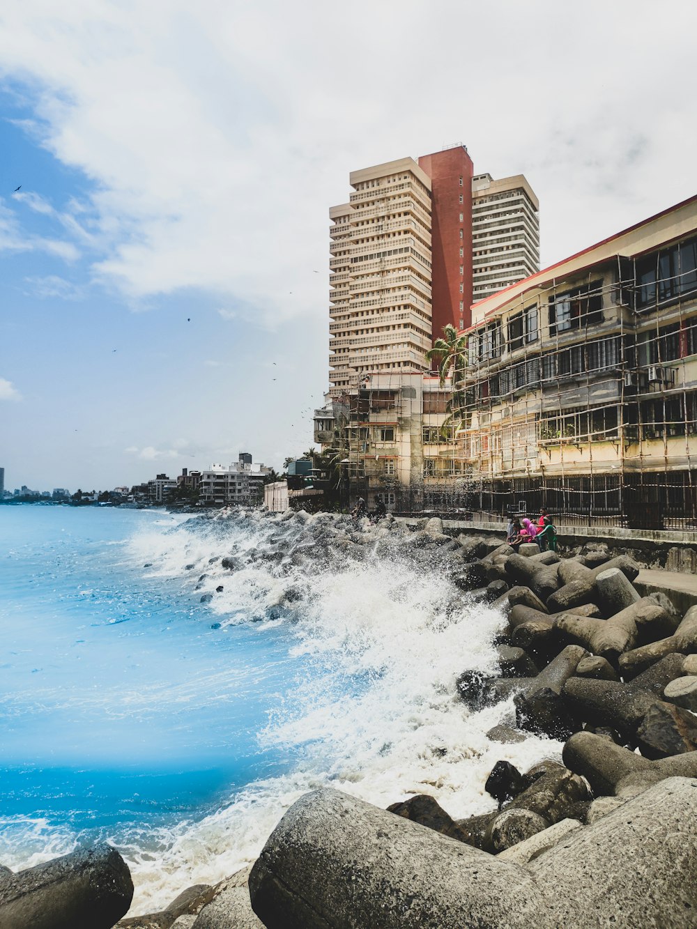 people on beach near brown concrete building during daytime