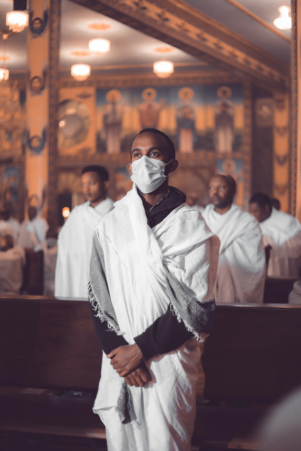 man in white robe wearing white mask