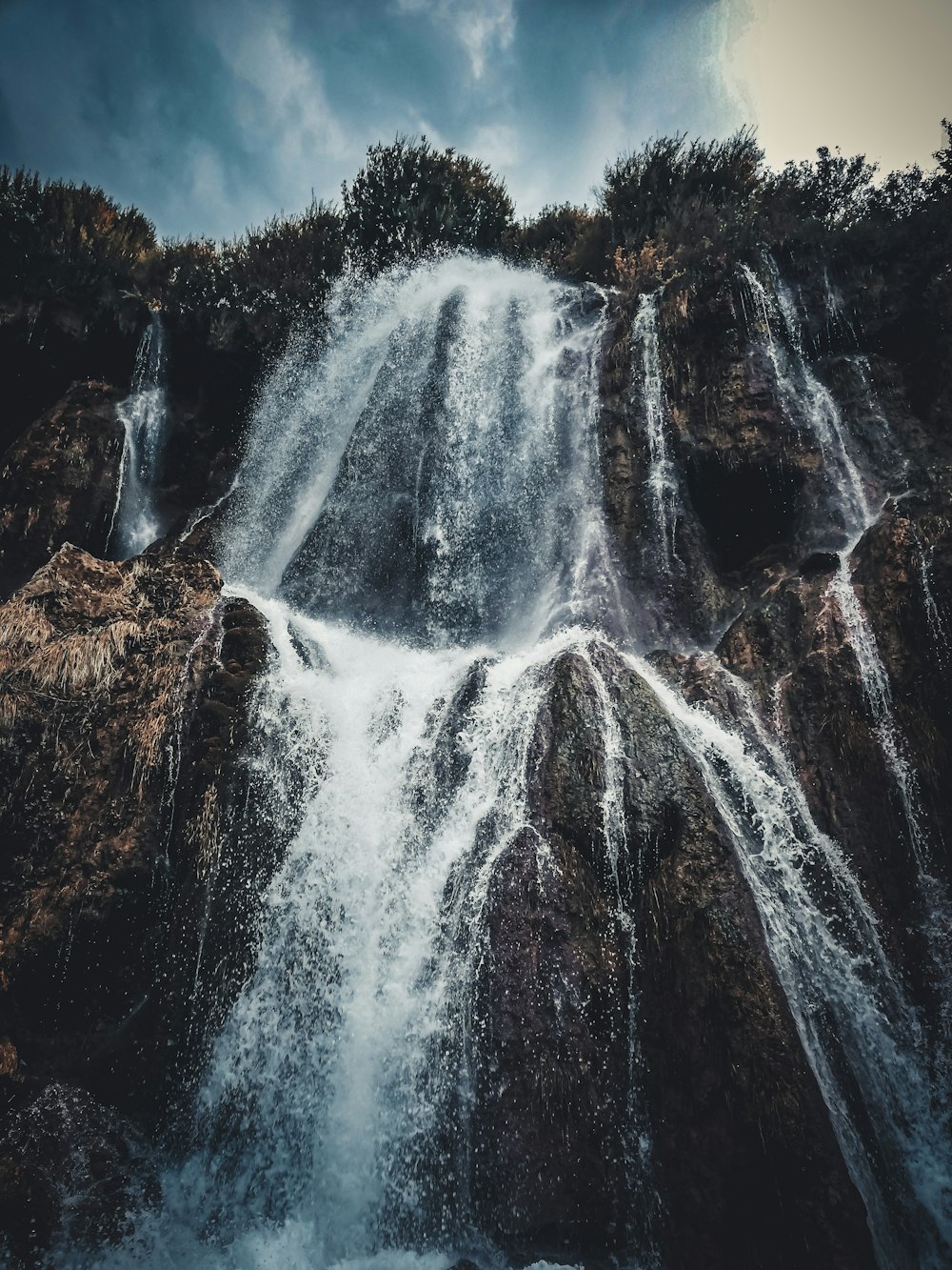 water falls in brown rocky mountain