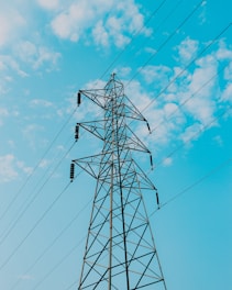 black electric post under blue sky during daytime