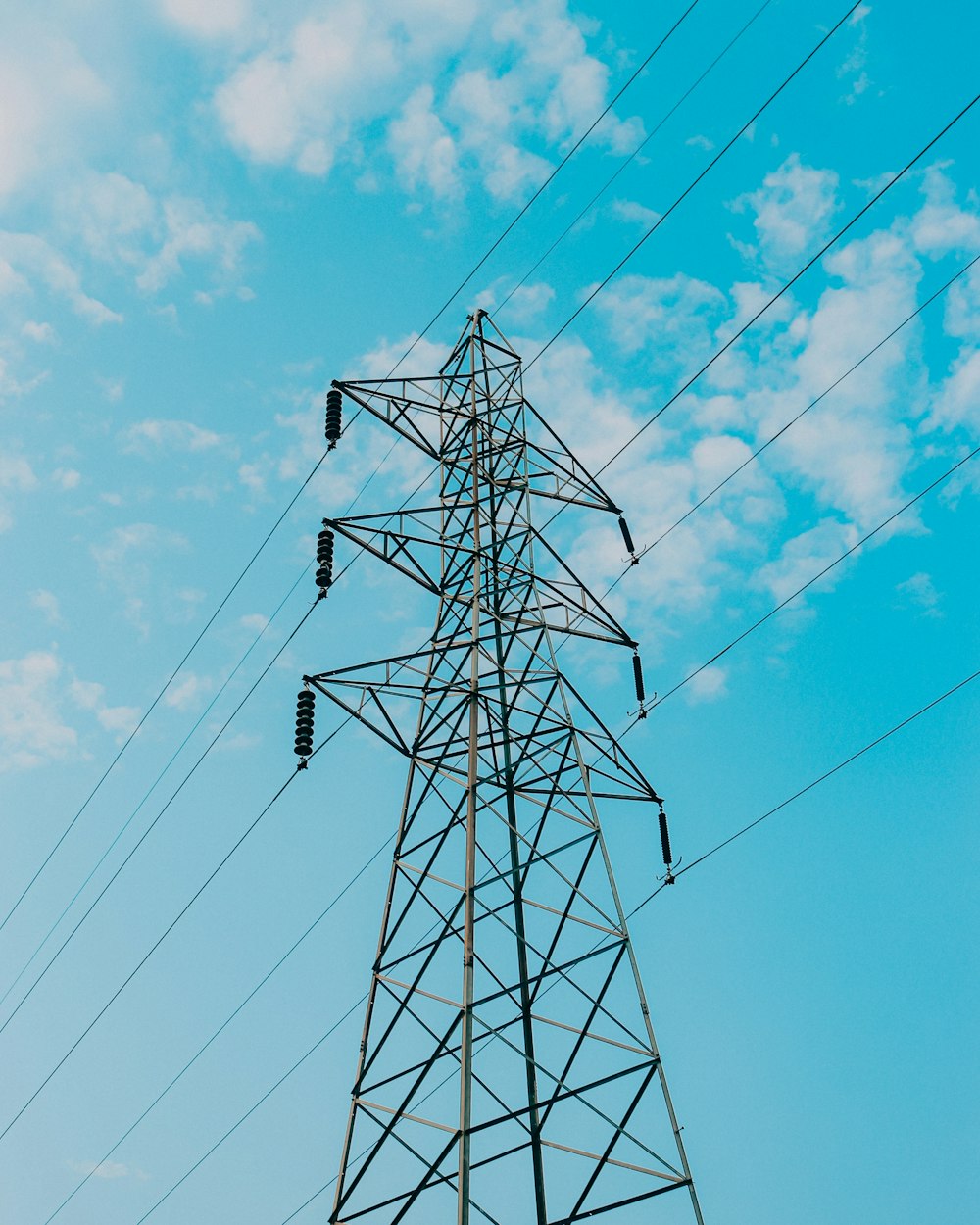 black electric post under blue sky during daytime