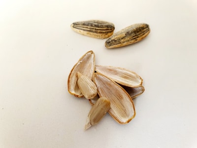 Sunflower seeds spilling from a burlap sack onto a rustic surface.