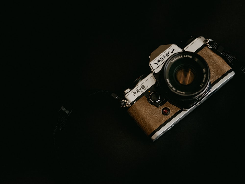Fotocamera marrone e argento su sfondo nero