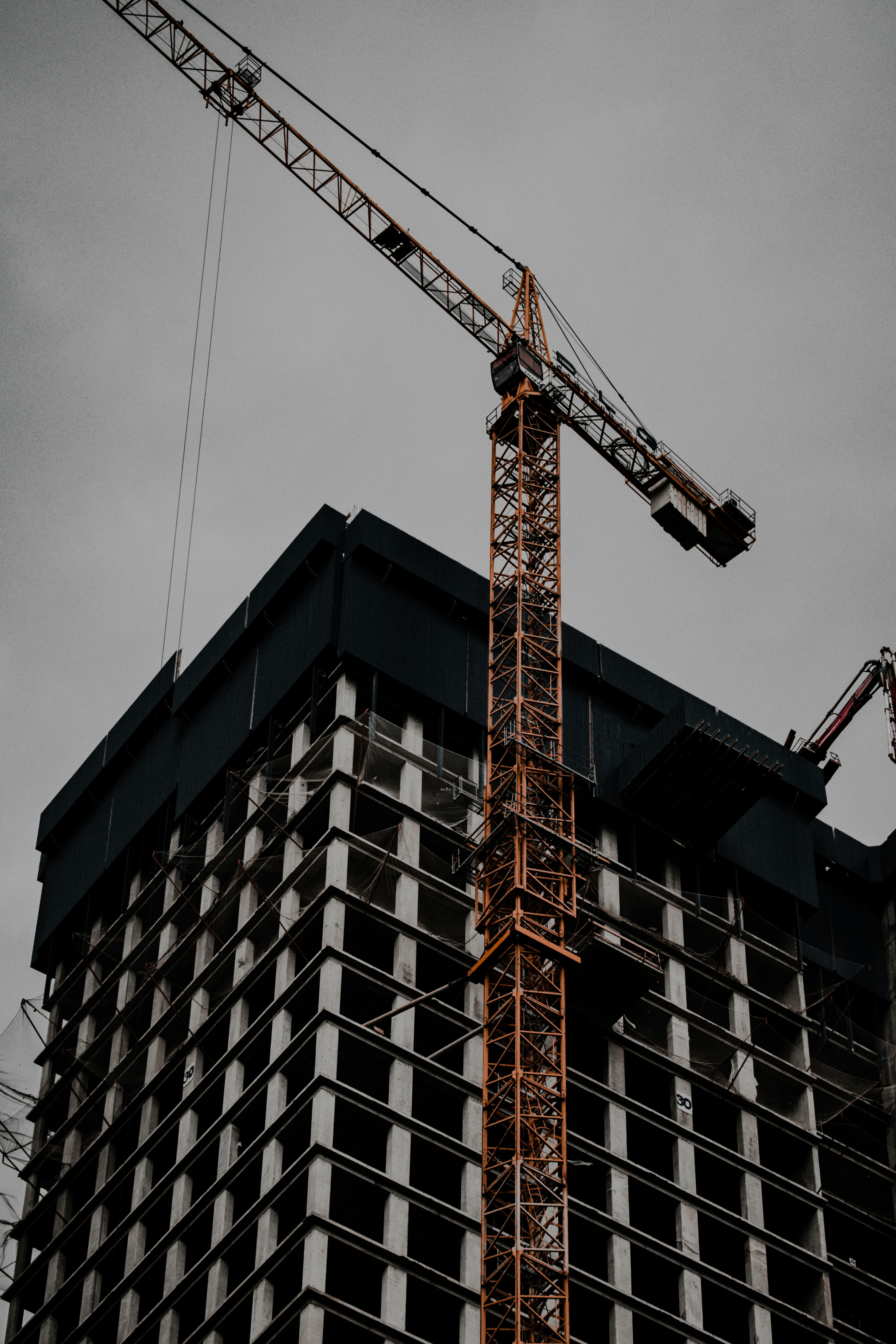 orange crane near brown building