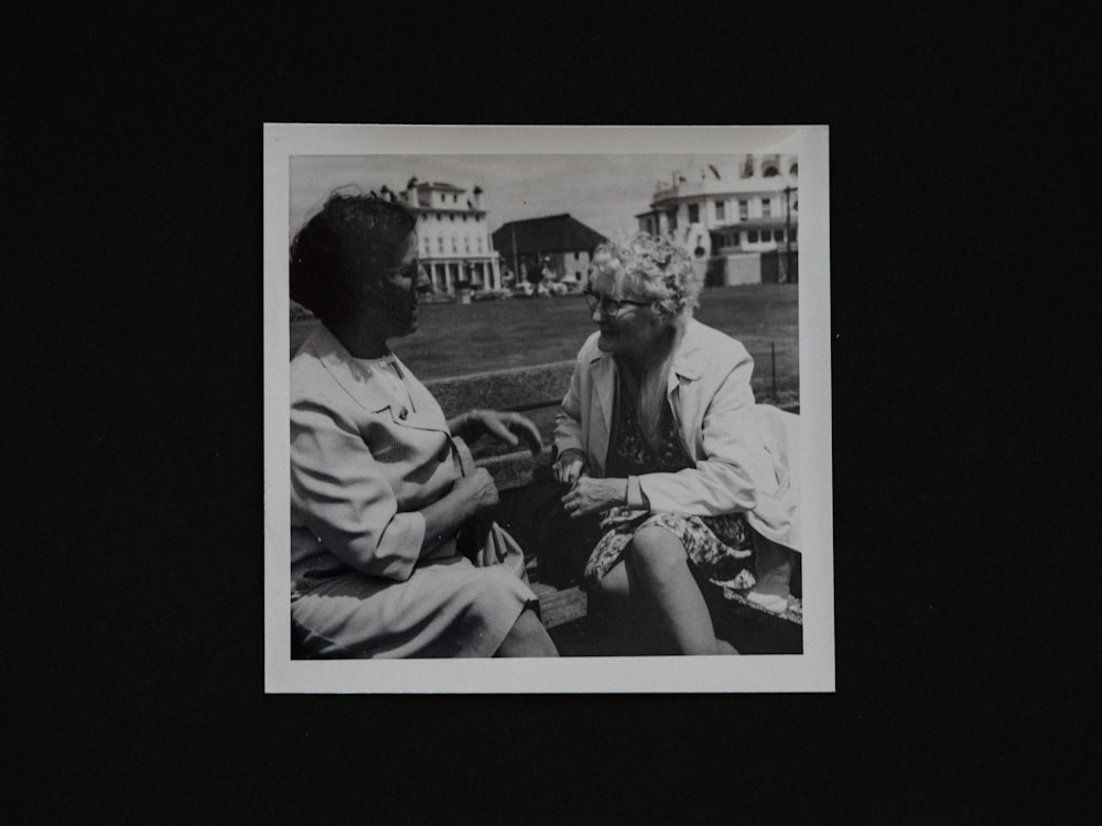 man in black suit jacket sitting beside woman in white dress