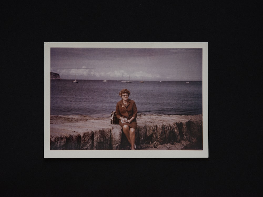 woman in brown bikini sitting on brown rock near body of water during daytime