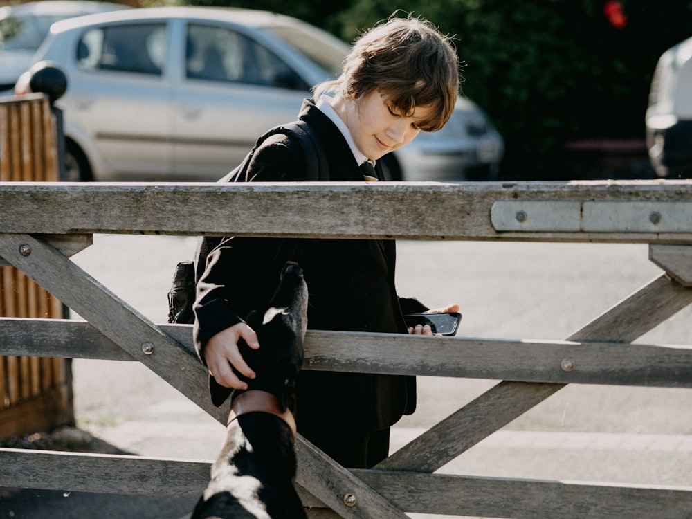 girl in black jacket sitting on brown wooden bench
