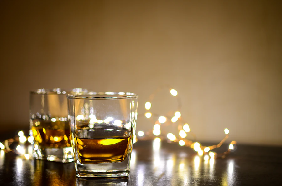 Two whisky glasses with warm amber liquid, illuminated by soft golden bokeh lighting