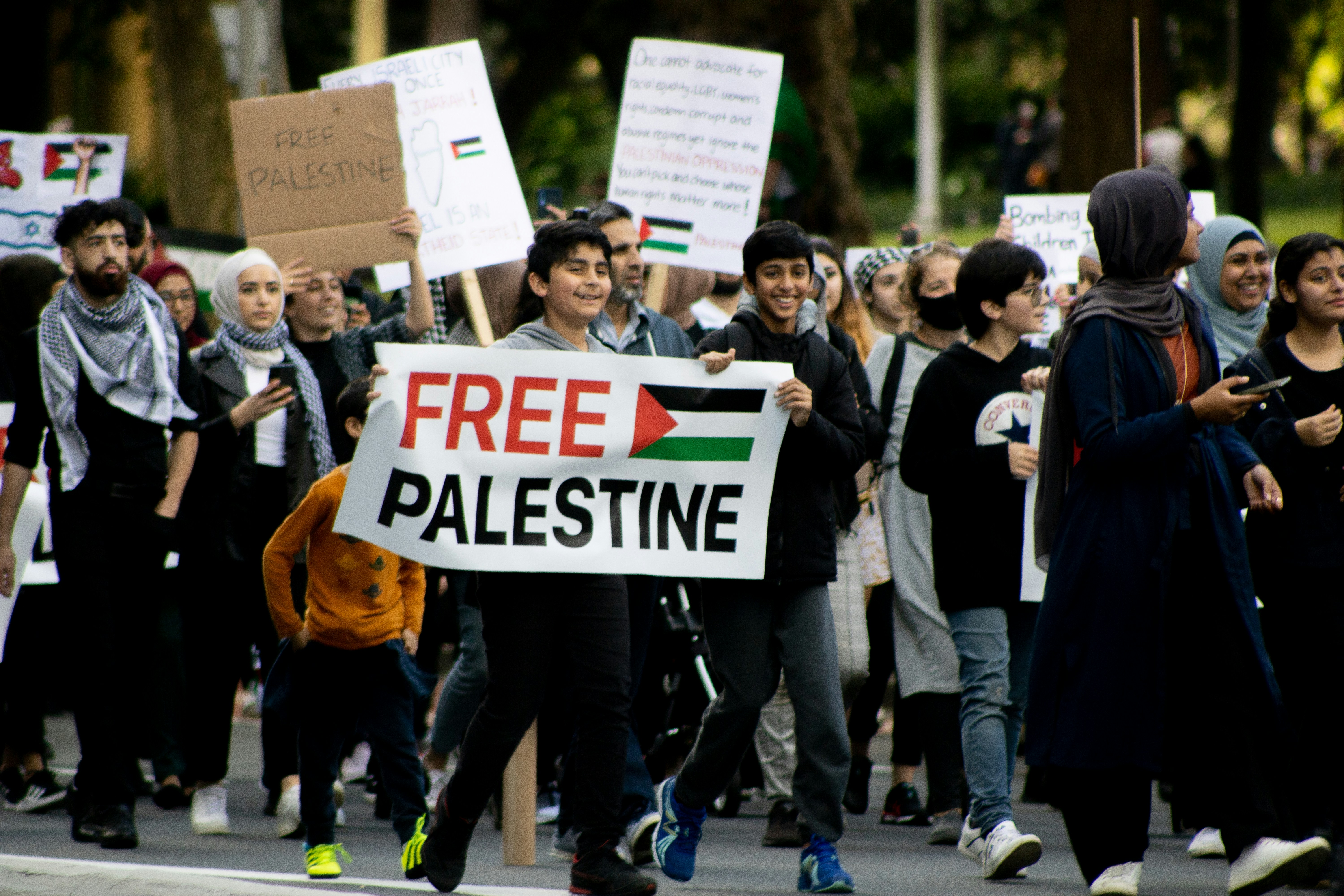 people holding white and orange signage during daytime