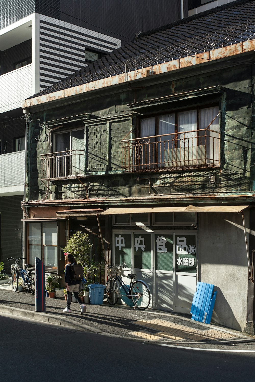 Personas caminando por la acera cerca de un edificio de concreto marrón y blanco durante el día