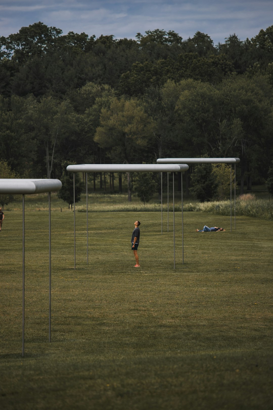 girl in red shirt and black shorts standing on green grass field during daytime