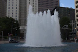 A water flosser in use beside a city apartment window showing a bustling skyline.