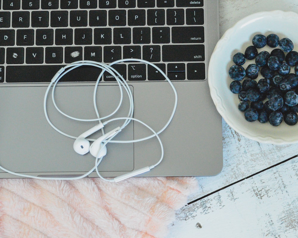 fones de ouvido brancos no macbook prateado