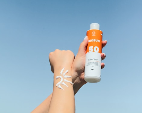 a person holding a bottle of sunscreen in their hand