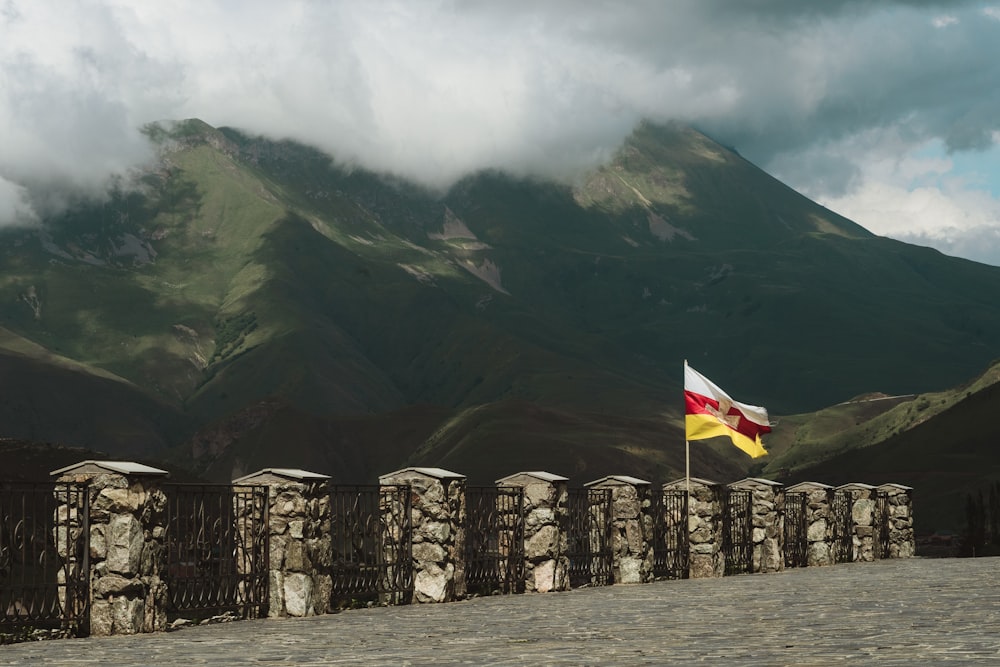 flags on poles near mountain during daytime