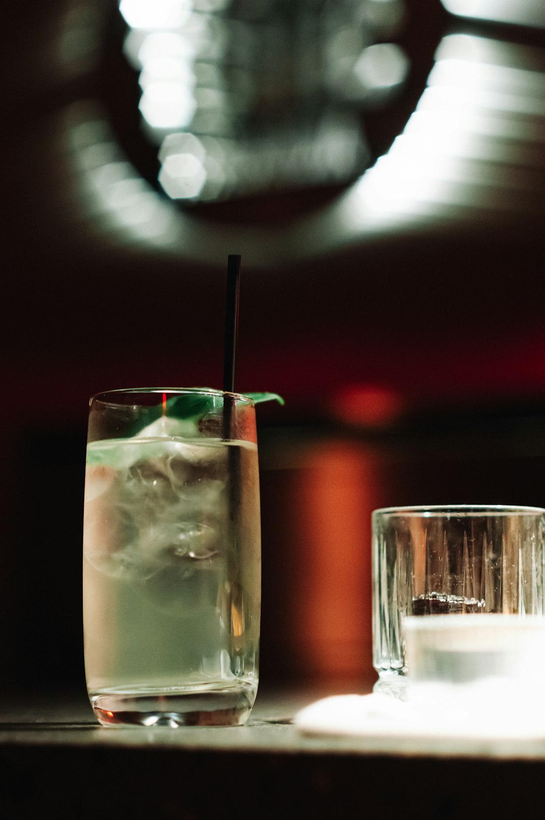 clear drinking glass with ice and straw