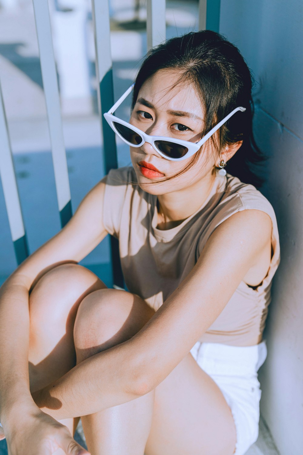 a woman sitting on a chair wearing a pair of sunglasses