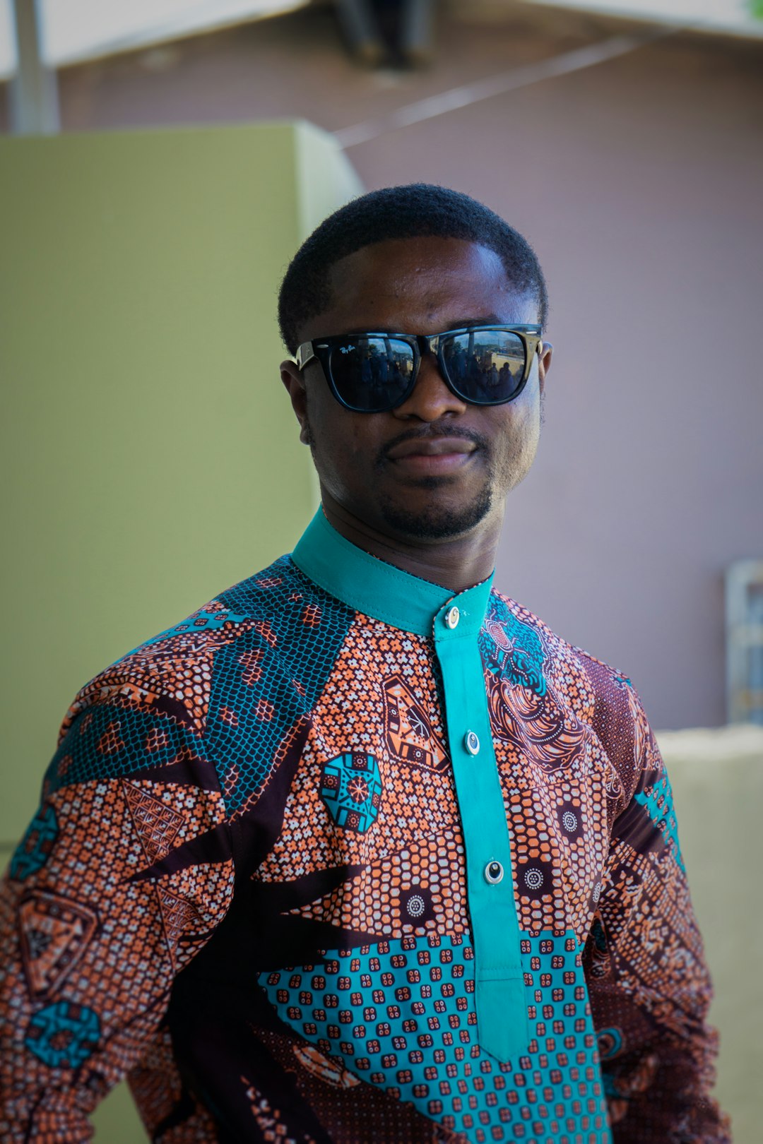 man in orange and blue button up shirt wearing black sunglasses