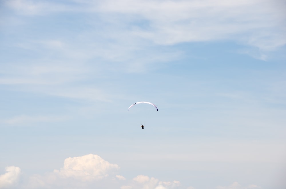 pessoa em paraquedas sob o céu azul durante o dia