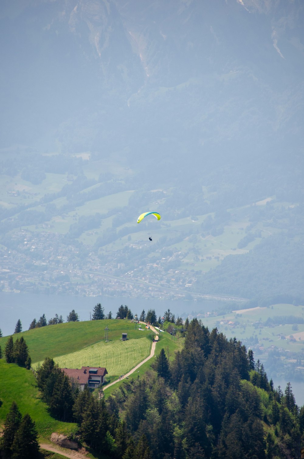 Paracaídas amarillo y azul sobre campo de hierba verde y árboles verdes durante el día
