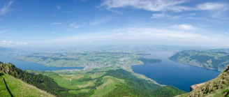 aerial view of green mountains and blue sea under blue sky during daytime
