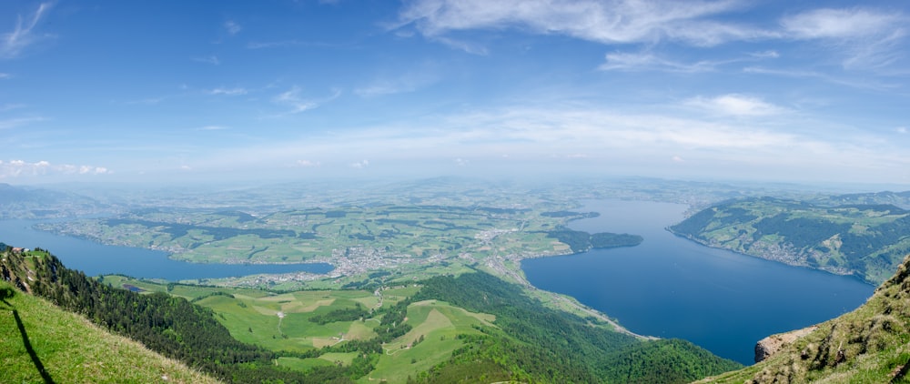 aerial view of green mountains and blue sea under blue sky during daytime