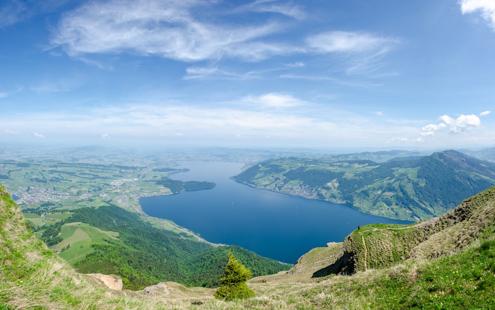 aerial view of green mountains and blue sea under blue sky during daytime