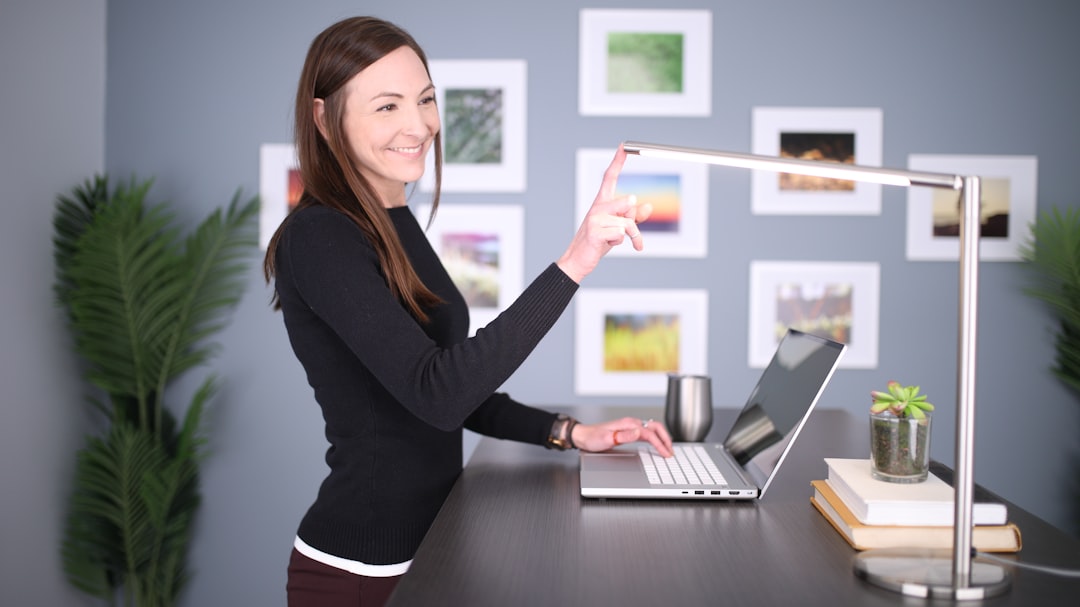 woman in black long sleeve shirt holding pen and macbook pro