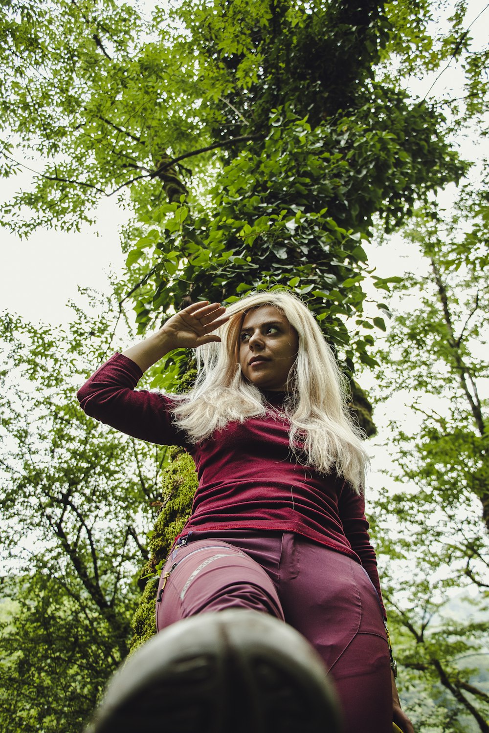 woman in red long sleeve shirt holding her hair