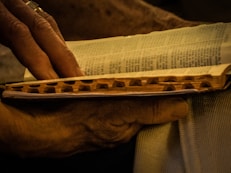 A close-up of hands gently turning the pages of a well-worn book.